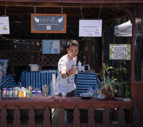 Volunteer serving drinks at the Plantify booth